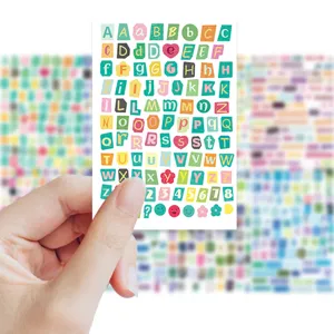 Primer plano de una hoja de pegatinas coloridas con letras y numeros para diario y manual.