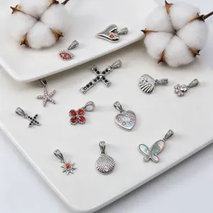 Detailansicht verschiedener Edelstahl-Zirkonia-Anhänger wie Schmetterling und Kreuz
