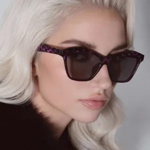 Detailed macro shot of stylish purple tortoiseshell cat-eye sunglasses worn by a model