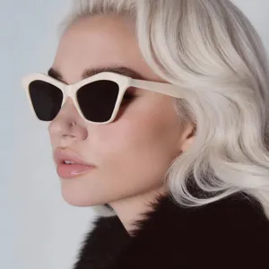 Detailed close-up of off-white cat-eye sunglasses worn by a blonde model in profile