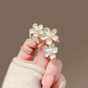 Dettaglio spilla floreale di perla squisita con petali delicati e foglie di cristallo scintillanti.