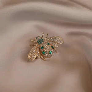 Exquisite vintage crystal bee brooch featuring sparkling rhinestones and green gems detail.