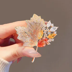 Exquisite rhinestone maple leaf brooch, luxury gold-tone metal, perfect autumn coat accessory.
