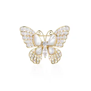Élégante broche papillon dorée ornée de perles et de zircone, idéale pour femmes élégantes.