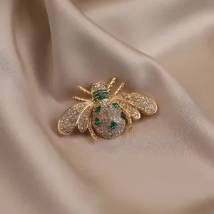 Close-up shot of an exquisite crystal bee brooch detailed with sparkling rhinestones and green gems.