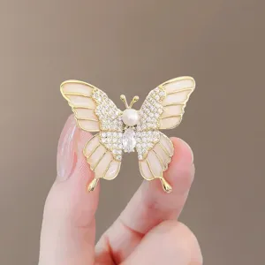 Élégante broche papillon avec perle et cristaux dans une finition dorée raffinée