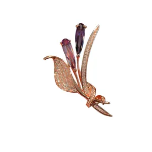 Dettaglio di raffinata spilla floreale in oro rosa con strass scintillanti e gemme viola.