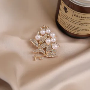 Pearl rhinestone brooch detailed shot, elegant gold flower branch design for women outfit decor.