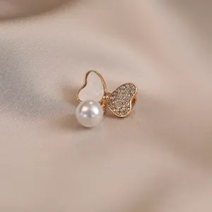 Close-up detail of luxury gold pearl rhinestone bow brooch pin for elegant women outfit