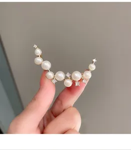 Pearl crescent moon brooch detail showing shiny rhinestones and elegant curved design.