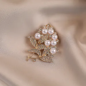 Elegant pearl rhinestone brooch pin, gold-toned floral fashion jewelry for sweaters and suits.