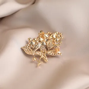 Close-up detail of the elegant gold floral rhinestone brooch pin, showcasing fine craftsmanship.