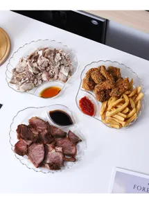 Assiette à raviolis en plastique transparent en forme de coquillage avec compartiment.