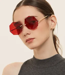 Stylish women's octagonal rimless sunglasses with red lenses and gold temples