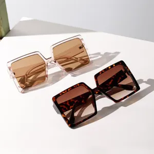 Gros plan de deux paires de lunettes de soleil carrées vintage sur fond blanc.