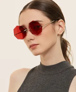 Detail shot of avant-garde red rimless octagonal sunglasses for women with metal arms