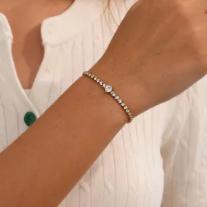 Close-up van minimalistische hart-diamanten armband om de pols met gouden afwerking, luxe