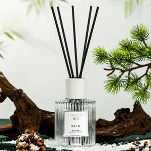 Set de difusor de varitas con palitos negros y botella de vidrio estriado para ambientador.