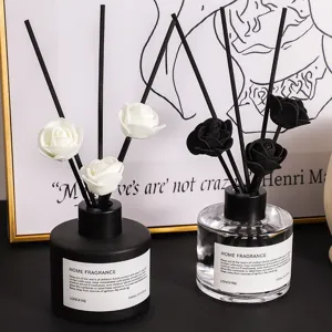 Minimalistische geurstokjes set met zwarte en doorzichtige flacons en mooie rozen.