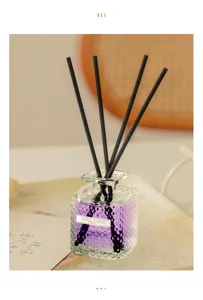 Home reed diffuser with purple liquid and black sticks in glass bottle for air freshener