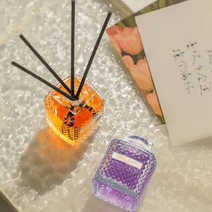 Glass aroma diffuser set with reed sticks and colored liquid for home air freshening.