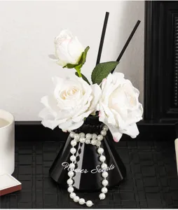 Close-up detail of artificial rose reed diffuser vase, elegant home decor aroma ornament.