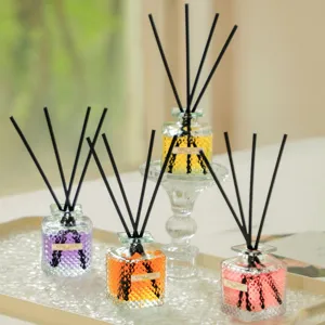 Home reed diffuser set with decorative glass bottles and black diffusing sticks for room fragrance.