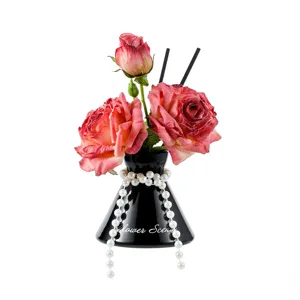 Artificial rose bouquet reed diffuser detail in black vase with pearls for home decor.
