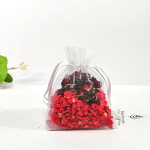 White organza sachet bag with red plant granules and dried flowers for wardrobe aromatherapy.