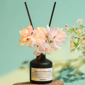 Nordic style reed diffuser with artificial flowers and black glass bottle for home fragrance.