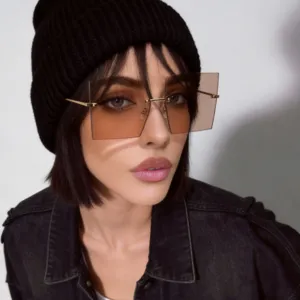 Close-up of oversized square rimless sunglasses with brown tinted lenses on model