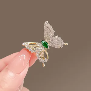 Exquisite rhinestone butterfly brooch with green gemstone. Elegant metal pin for women.