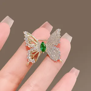 Exquisite butterfly brooch detail showing sparkling rhinestones and green crystal centerpiece pin.