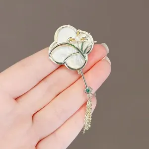Detailed view of exquisite Chinese style fan brooch with pearl and delicate tassel pin.