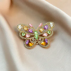 Detailed close-up shot of a colorful crystal rhinestone butterfly brooch with fine gold finish.
