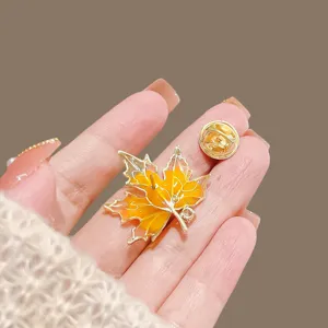 Exquis detail de broche feuille d'erable doree, elegante epingle emaillee pour femmes.