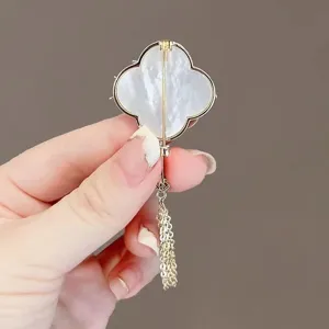 Exquisite four-leaf clover brooch back detail, white shell inlay with delicate gold tassel.