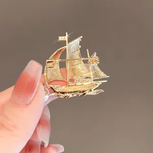 Elegant golden sailboat brooch with sparkling crystals, perfect suit accessory for men and women.