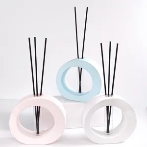 Moderne ringvormige vlamloze aromadiffuser met glazen buisje en zwarte stokjes, set van drie stuks.
