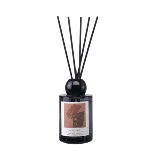 Black glass diffuser bottle with reed sticks and decorative label for home decor.