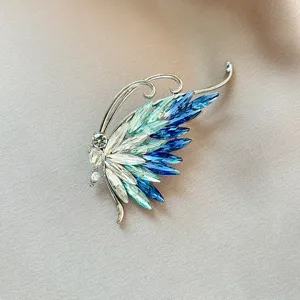 Crystal butterfly wing brooch detail shot, elegant gradient blue rhinestone accessory for suit.