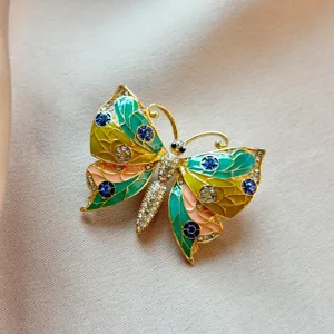 Exquisite rhinestone butterfly brooch detail view, elegant gold plated enamel fashion pin accessory.