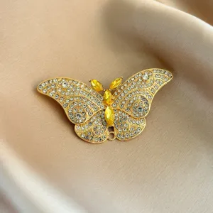 Crystal butterfly brooch detail showcasing intricate rhinestone pavé work and yellow center stones.