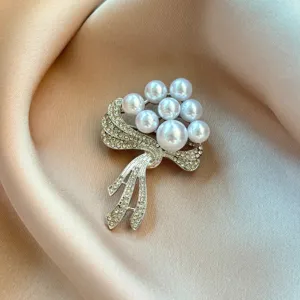 Exquisite pearl flower brooch pin with sparkling rhinestones, elegant clothing accessory for women.