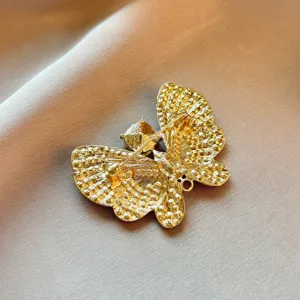 Detailed view of the exquisite gold-tone butterfly brooch back structure, high quality craftsmanship.