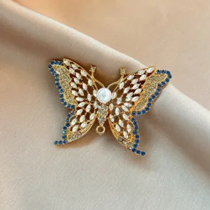 Elegant crystal butterfly brooch featuring sparkling rhinestones and pearl, detailed view.