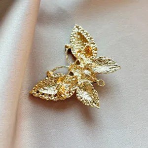 Gold butterfly brooch back view, metal pin fastening, exquisite clothing accessory detail.