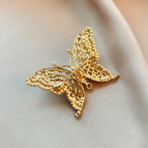 Detailed back view of the vintage hollow gold butterfly brooch, showing secure pin and loop.