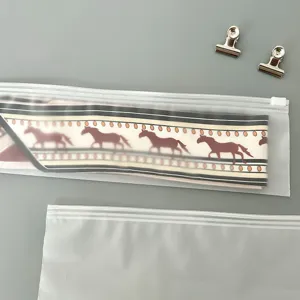 Detail view of a long printed twilly ribbon inside a frosted ziplock packaging bag.