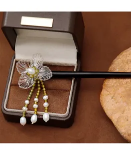 Gros plan sur la fleur tissée main et le pompon en perles sur pic à cheveux en ébène